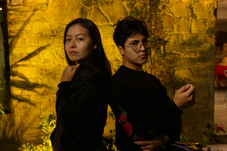 two people posing for a po in front of a rock