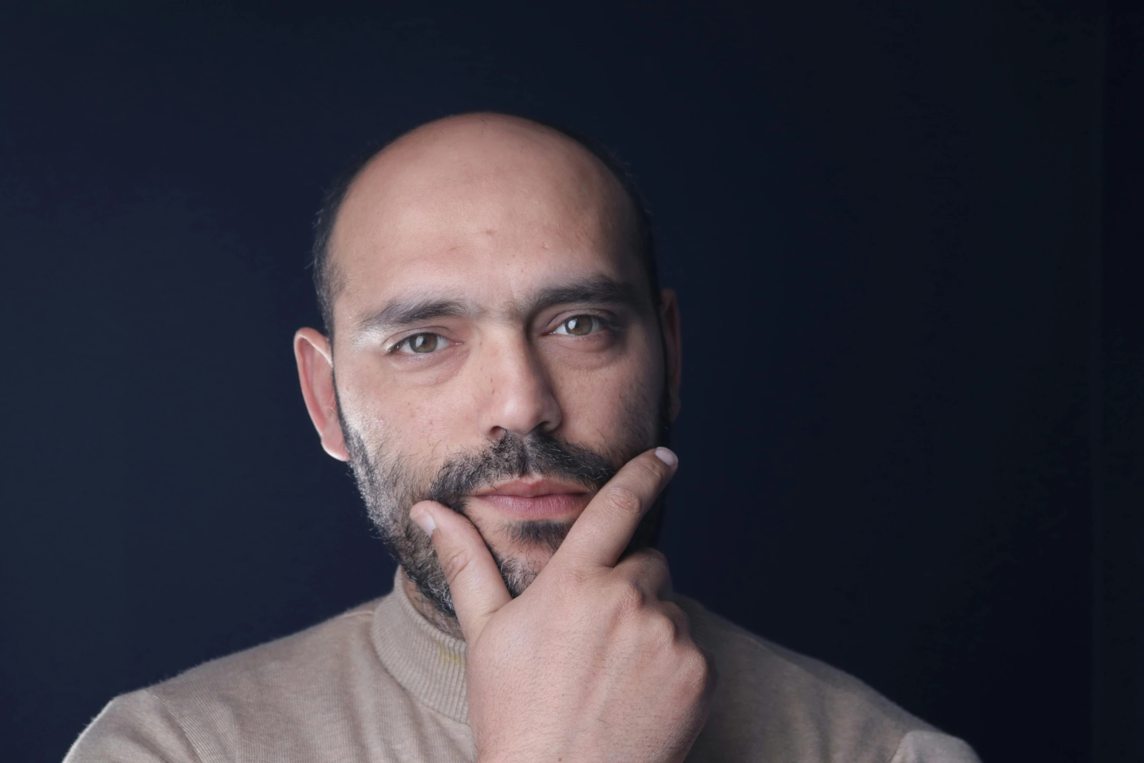 a balding man looks into the camera, as if he is doing soing