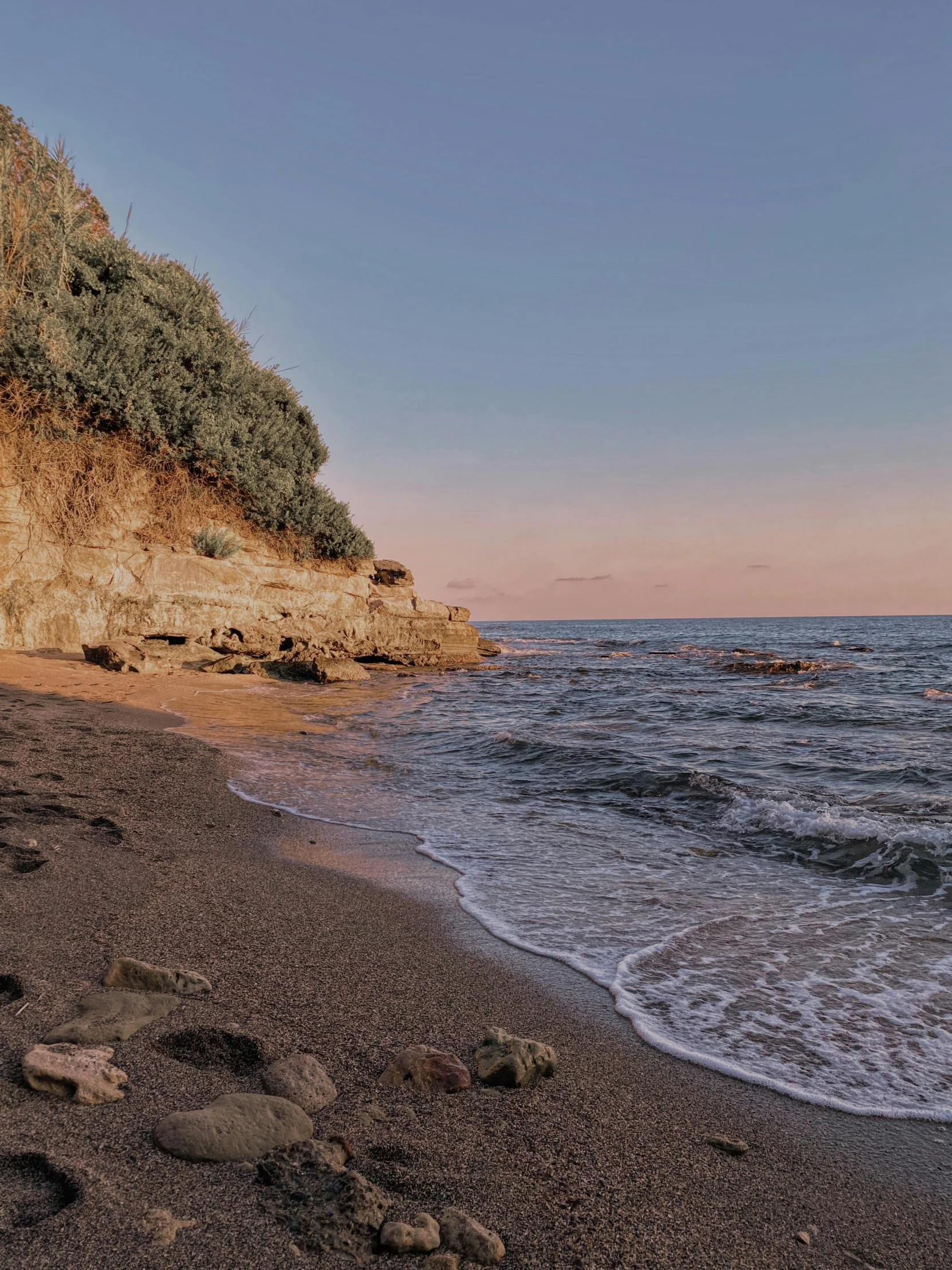 the water is calm and empty on the beach