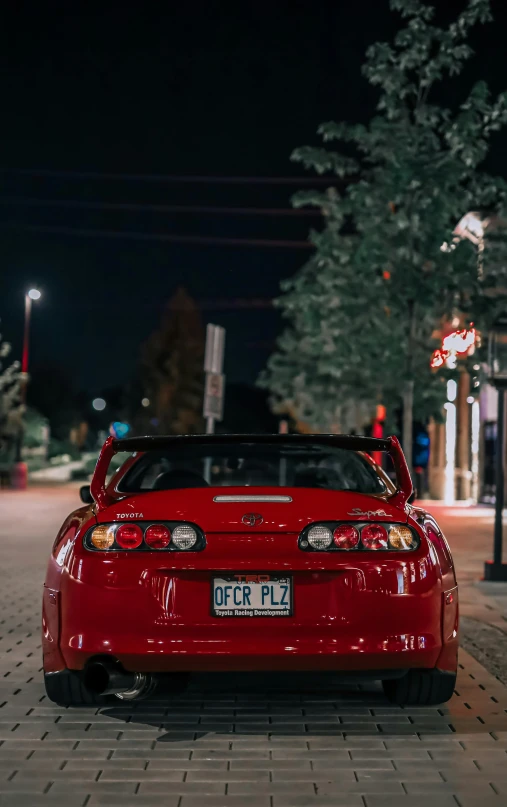 a red sports car is parked near street lights