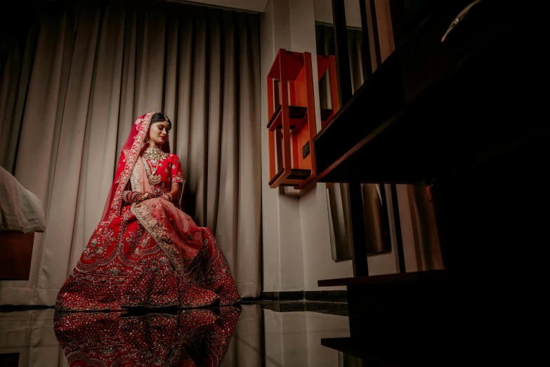 bride in red wedding dress standing near piano