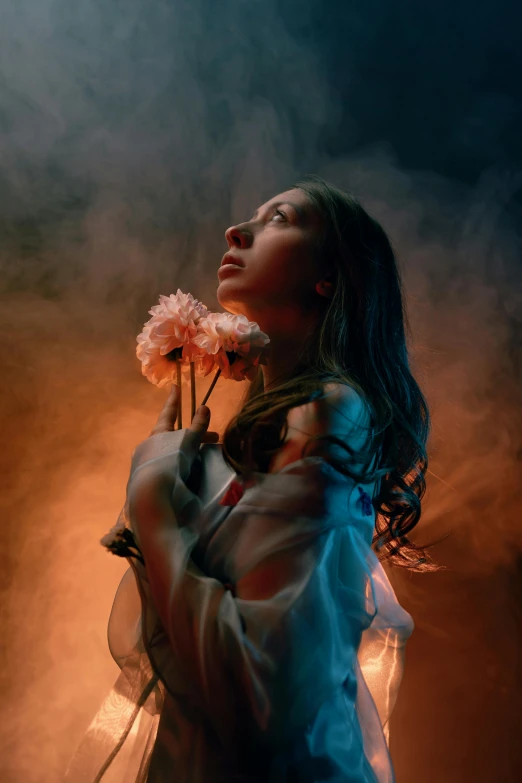 a woman holding flowers looks up into the sky