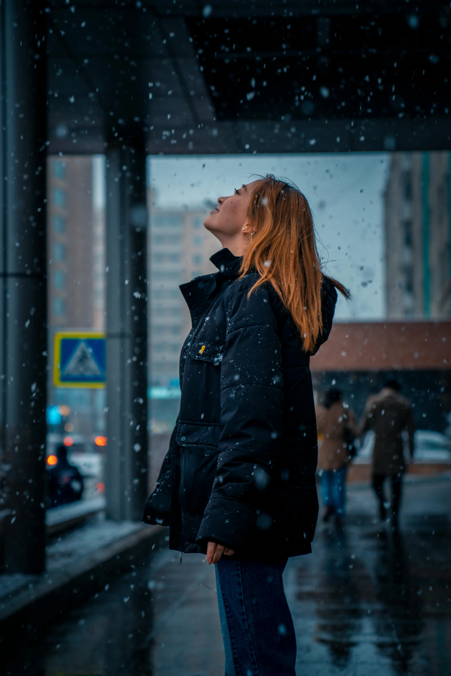 a woman is standing under a umbrella while it's raining