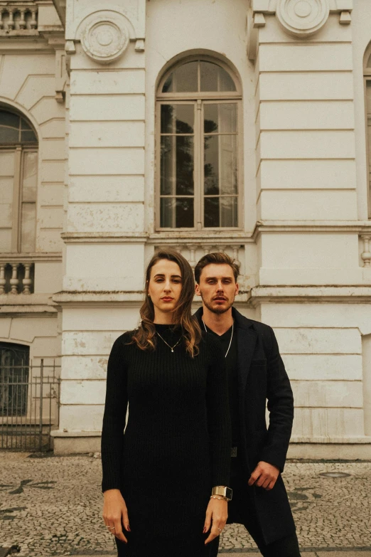 a man and a woman stand outside a building