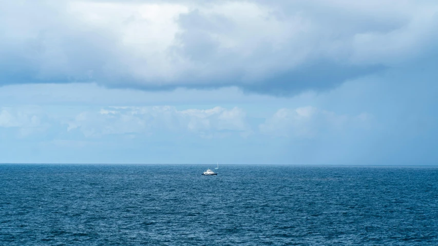 a large body of water with a boat in the distance