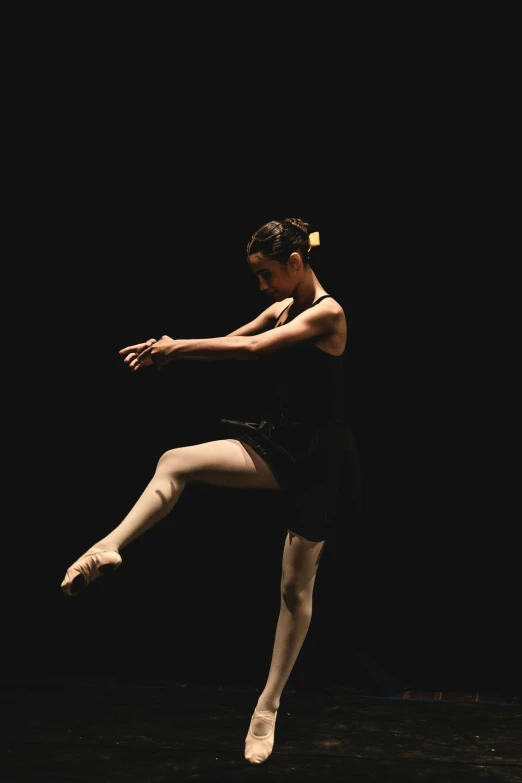 a dancer in a dark room on her legs