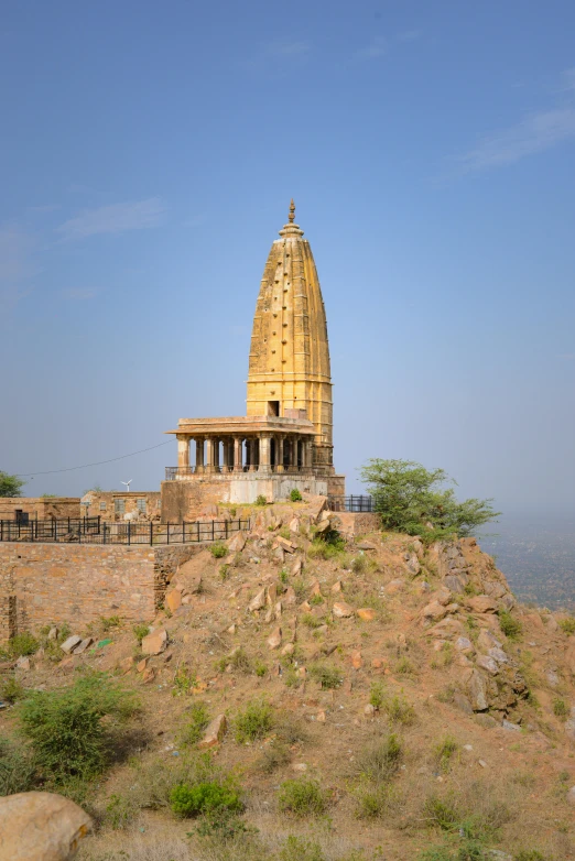 a large building on a hill with trees