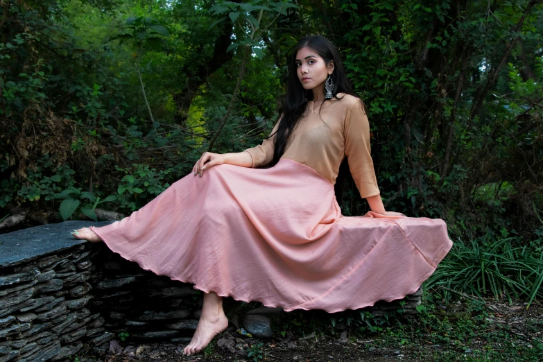 an image of a woman sitting on the side of a rock wall