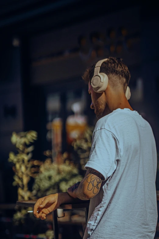 a man wearing a white shirt has his arm tattooed