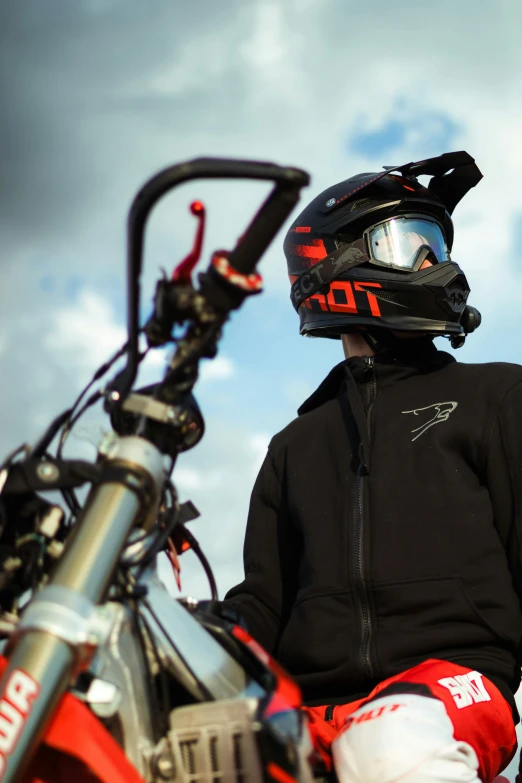 a motorcyclist waits on his bike in the open