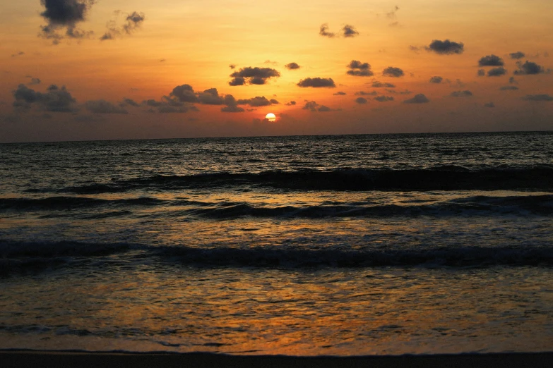 the sun is rising over the ocean in a twilight