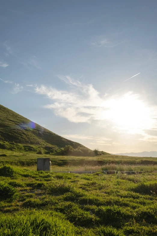 the sun is shining brightly above a hill