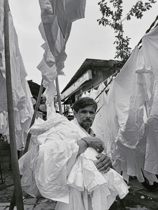 a man holding a person in his arms in front of clothes