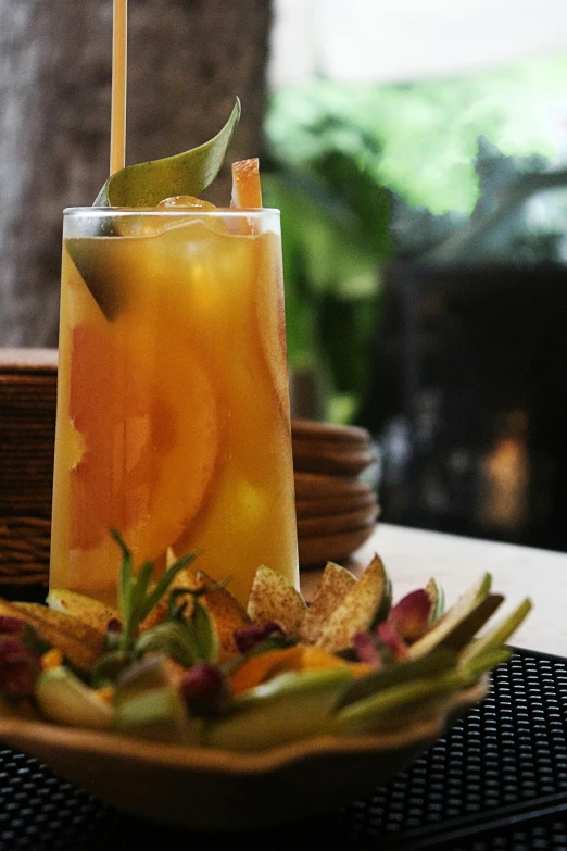 a fancy cocktail sits on a plate with a drink in it