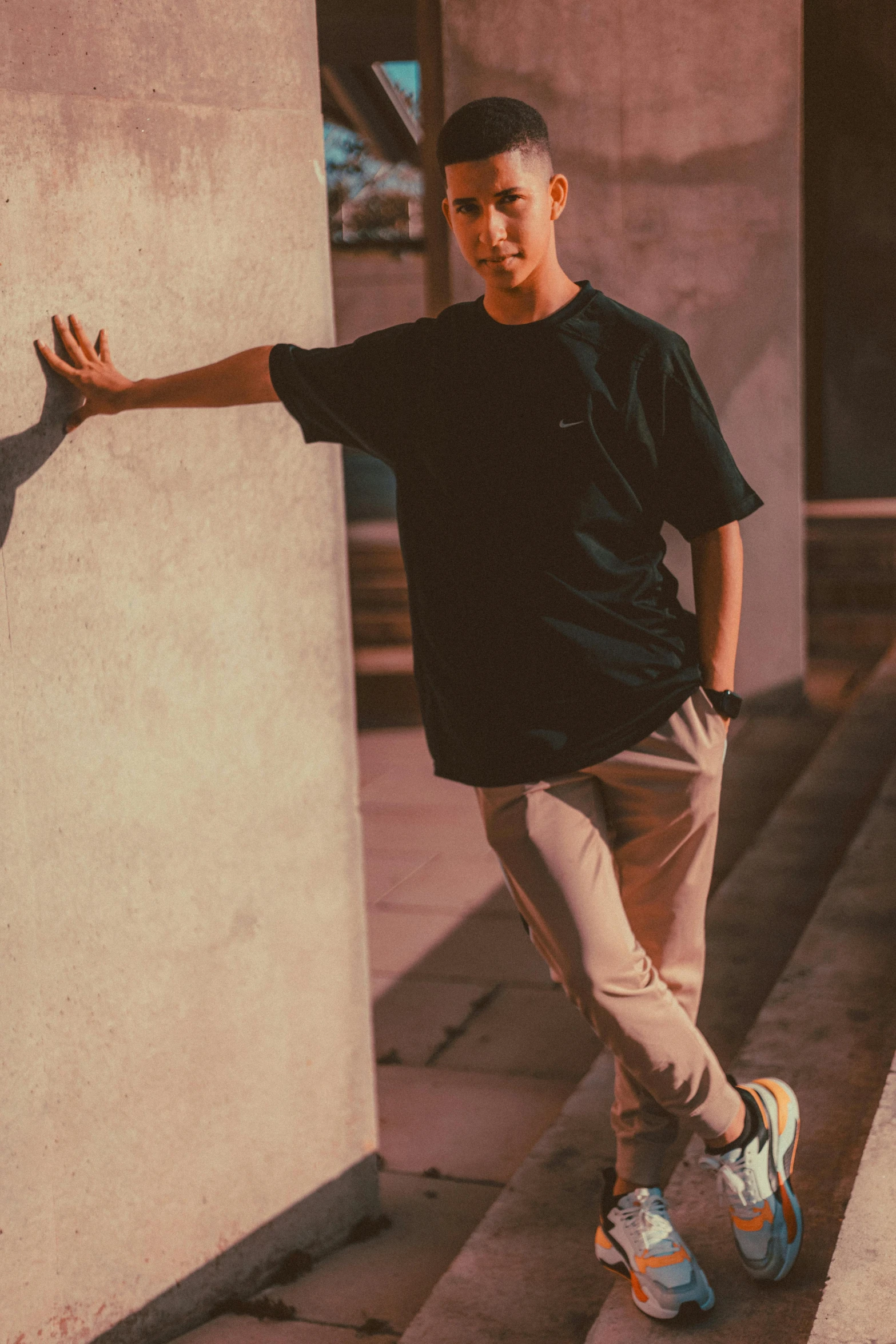 a boy standing on his skateboard against the side of a building