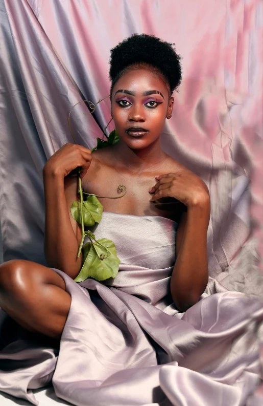 a woman sitting down holding flowers in her hand