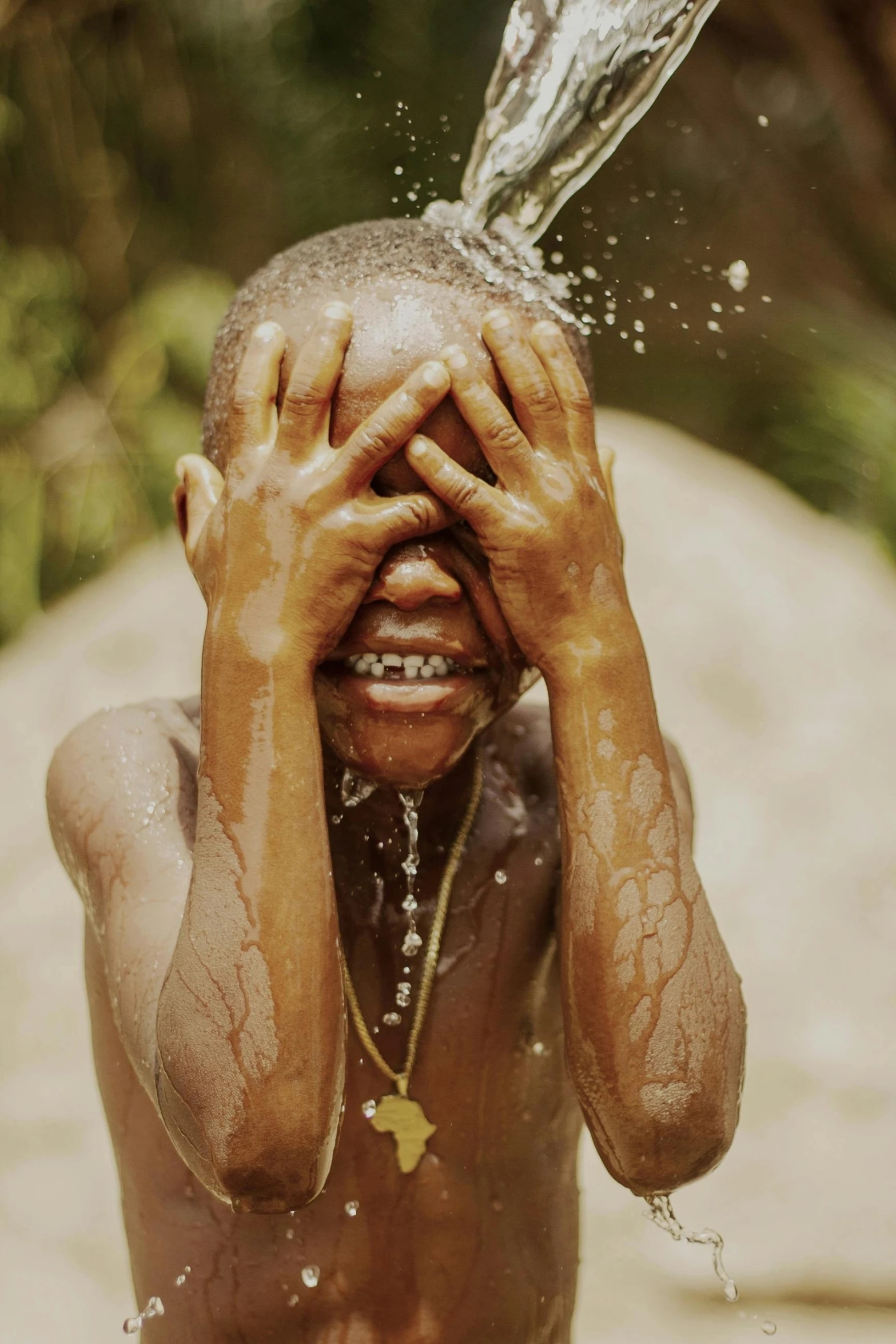 a child with his face covered and splashing water