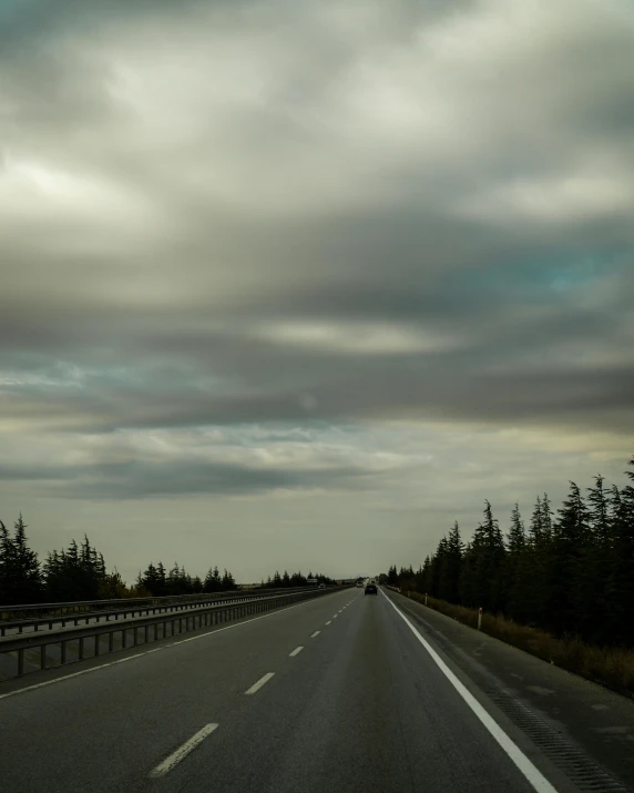 a cloudy highway with several signs on it