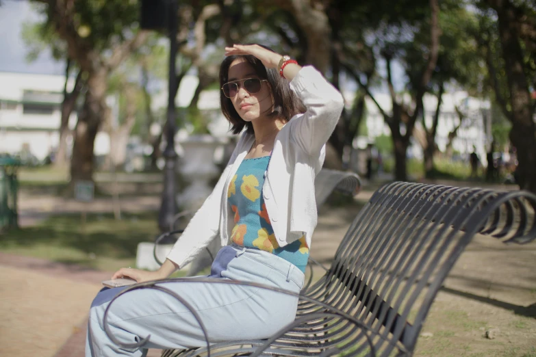 a woman sitting on top of a black park bench