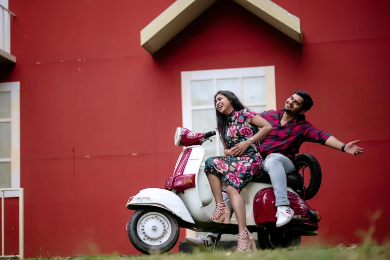 man and woman riding scooter in front of building