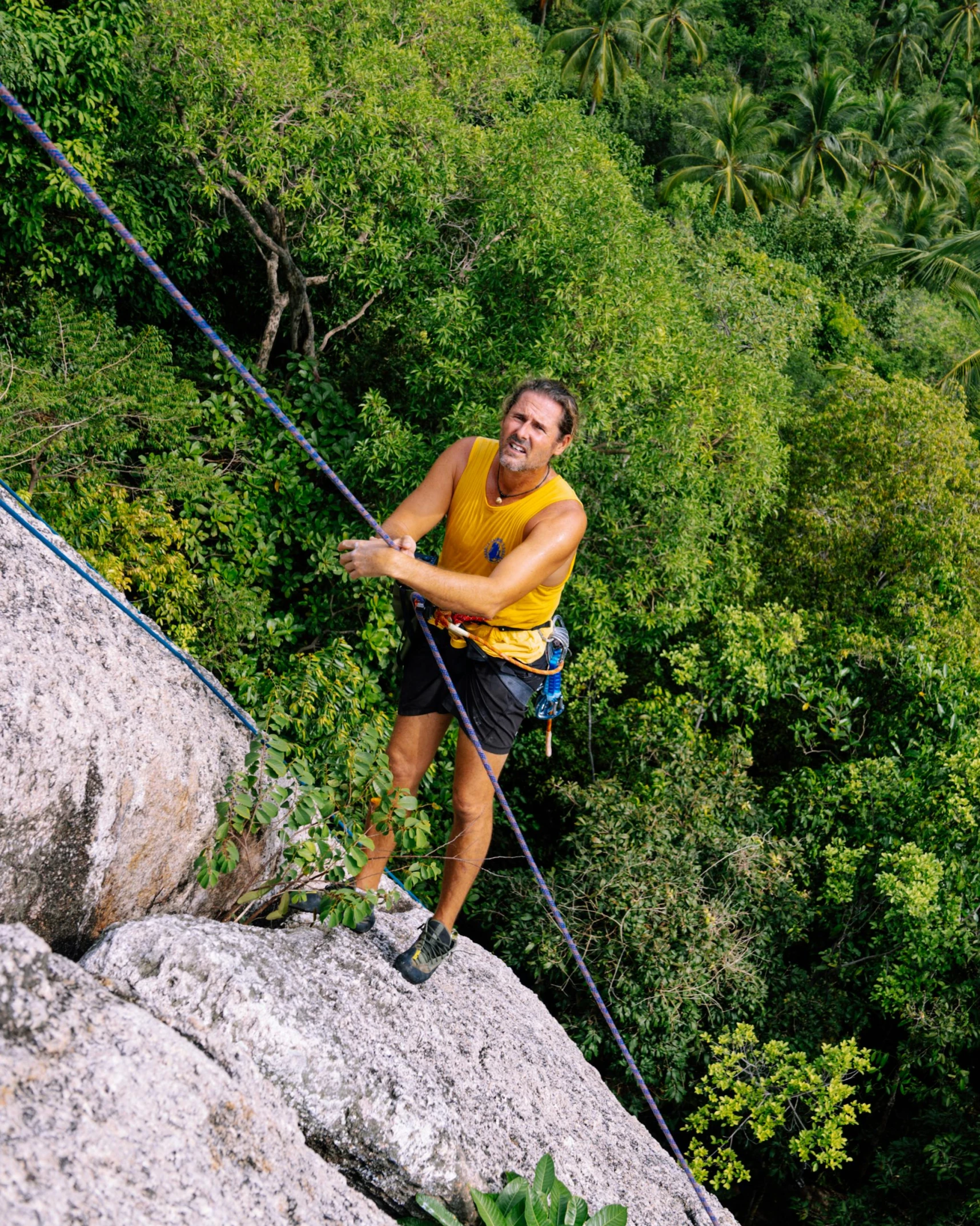 a man is climbing on the side of a large rock