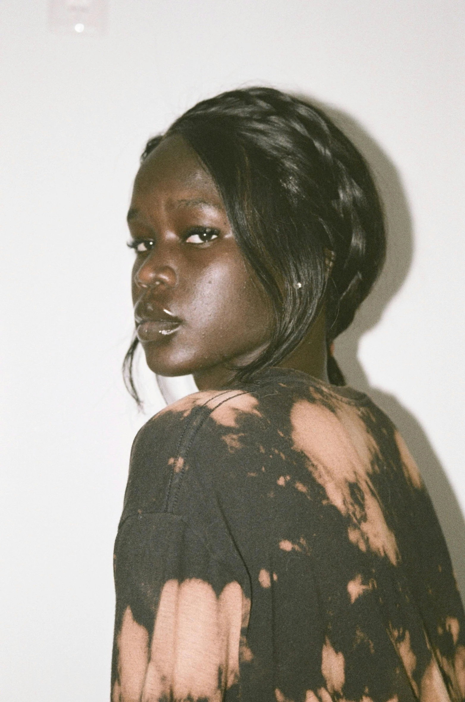 woman looking up while wearing t - shirt with black and brown stains