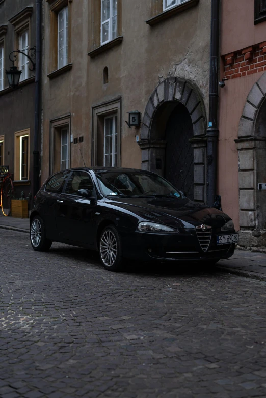 a black car is parked in front of buildings