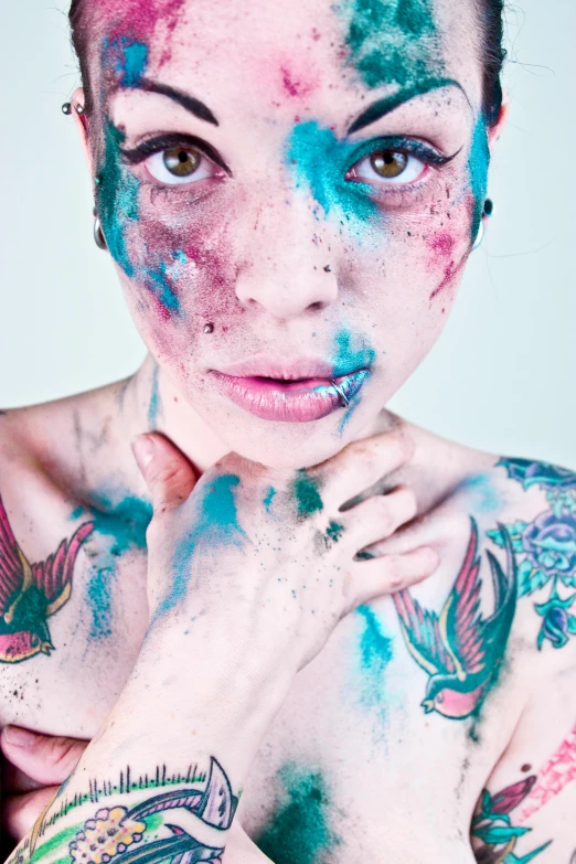 a young woman covered in paint posing for a po