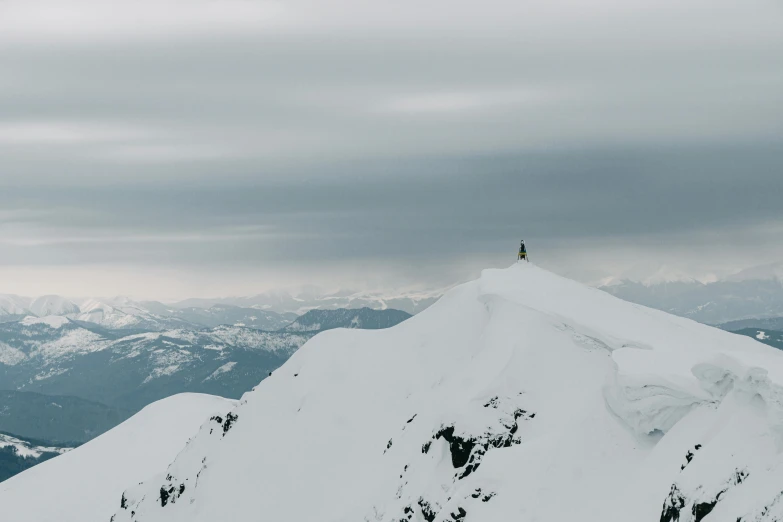 a man on a snowy mountain top with snowboarding gear