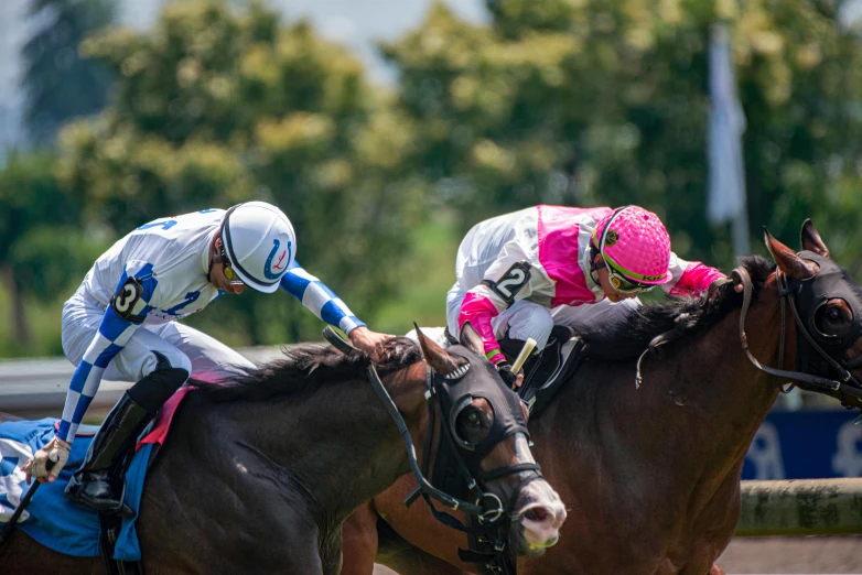 two men riding horses in the dirt race