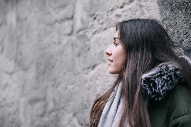 a young woman with long brown hair wearing a gray and black scarf