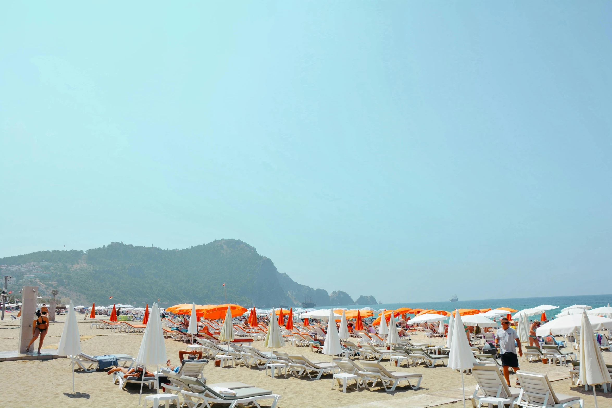 an outdoor beach with umbrellas and chairs on the sand