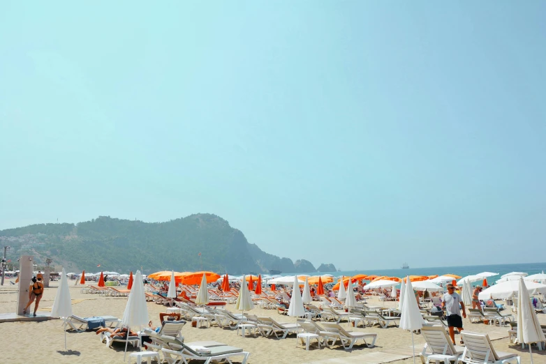 an outdoor beach with umbrellas and chairs on the sand