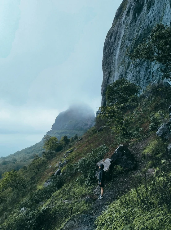 people are hiking along a steep hill on a trail