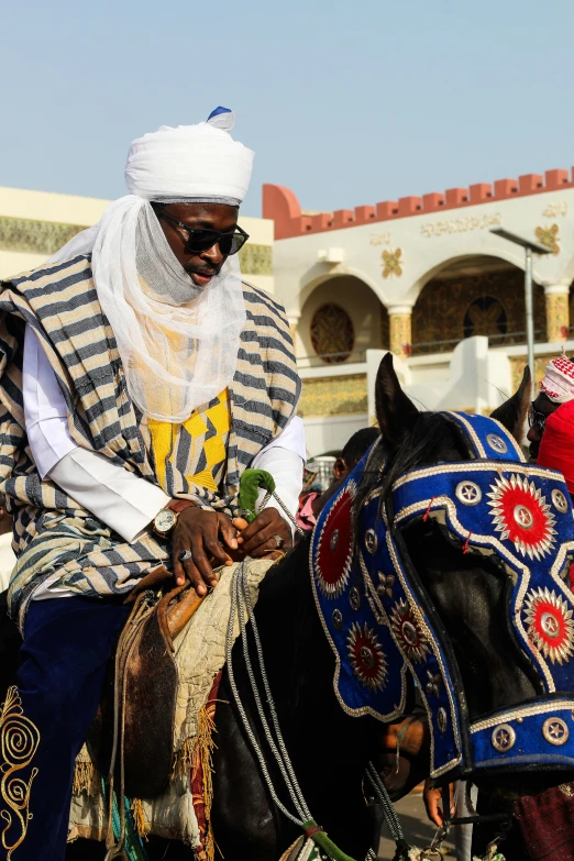 a man with a turban sits on a horse