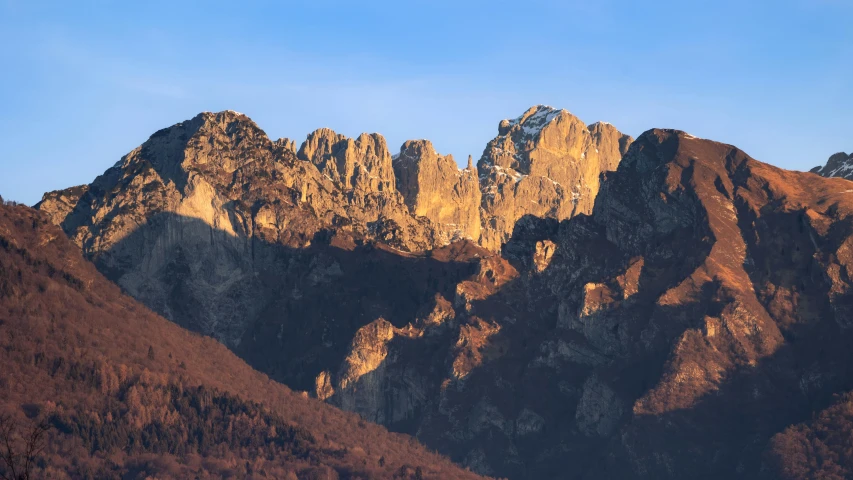 the very tall mountains are covered in brown and white snow