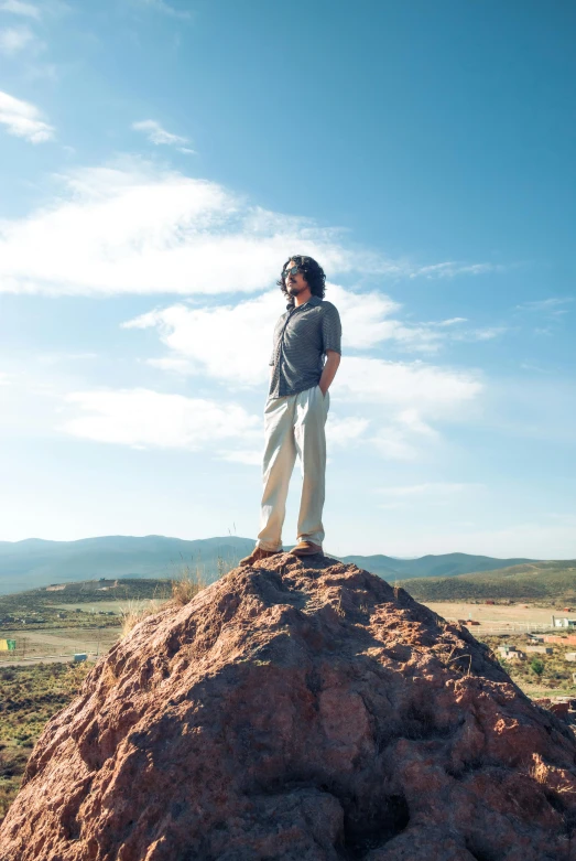 a person stands on top of a large rock