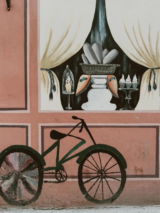 a bike parked next to a mural on the side of a building