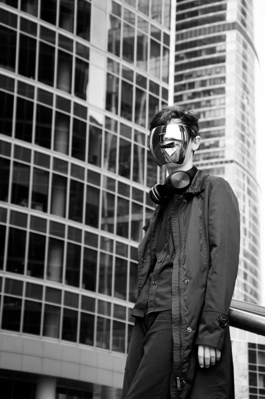 woman in all black with silver mask outside of building