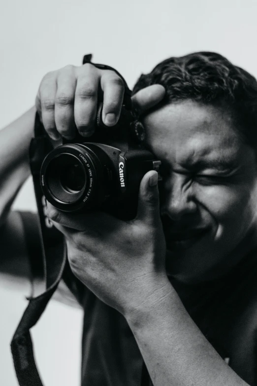 a man with a camera that is looking at the reflection