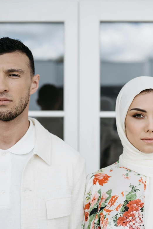 two people that are standing together near a window