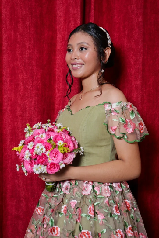 a young woman in a dress holding a large bouquet of pink flowers