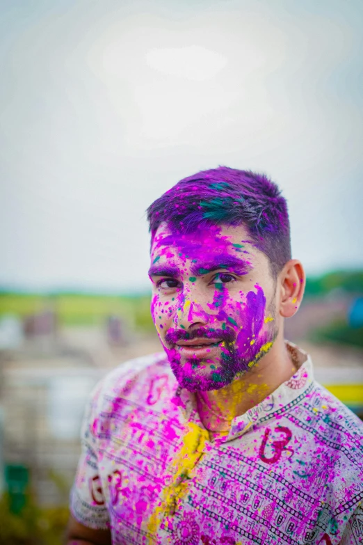 a young man is smeared with purple paint