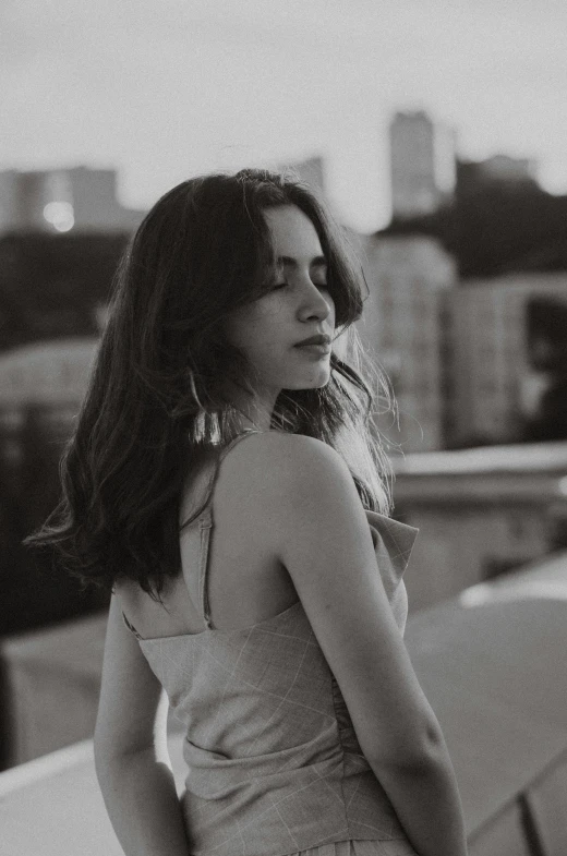 black and white po of woman in front of rooftop