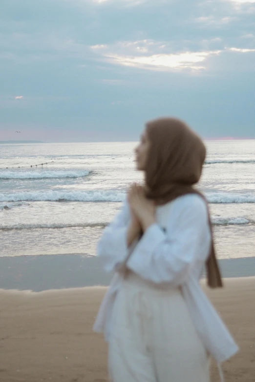 a woman walking on a beach near the ocean