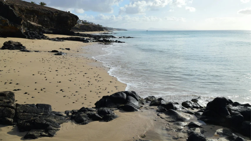 a beach that has some rocks and sand