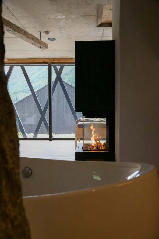 a large bathtub sitting under a window next to a fire place