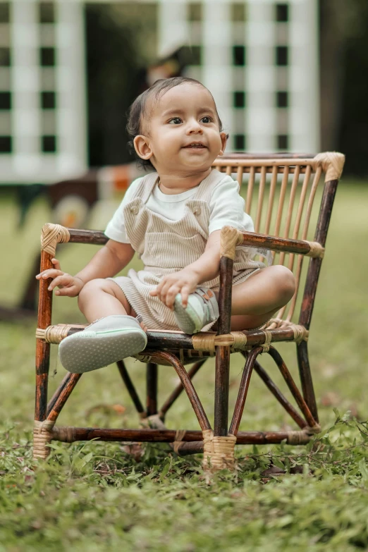 small toddler sitting in an old wooden rocking chair