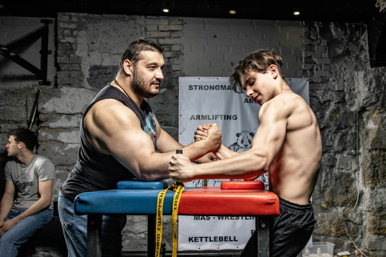 two men wrestling in a competition with one being on the bench