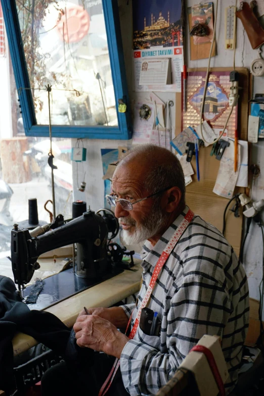 an old man sitting at a sewing machine